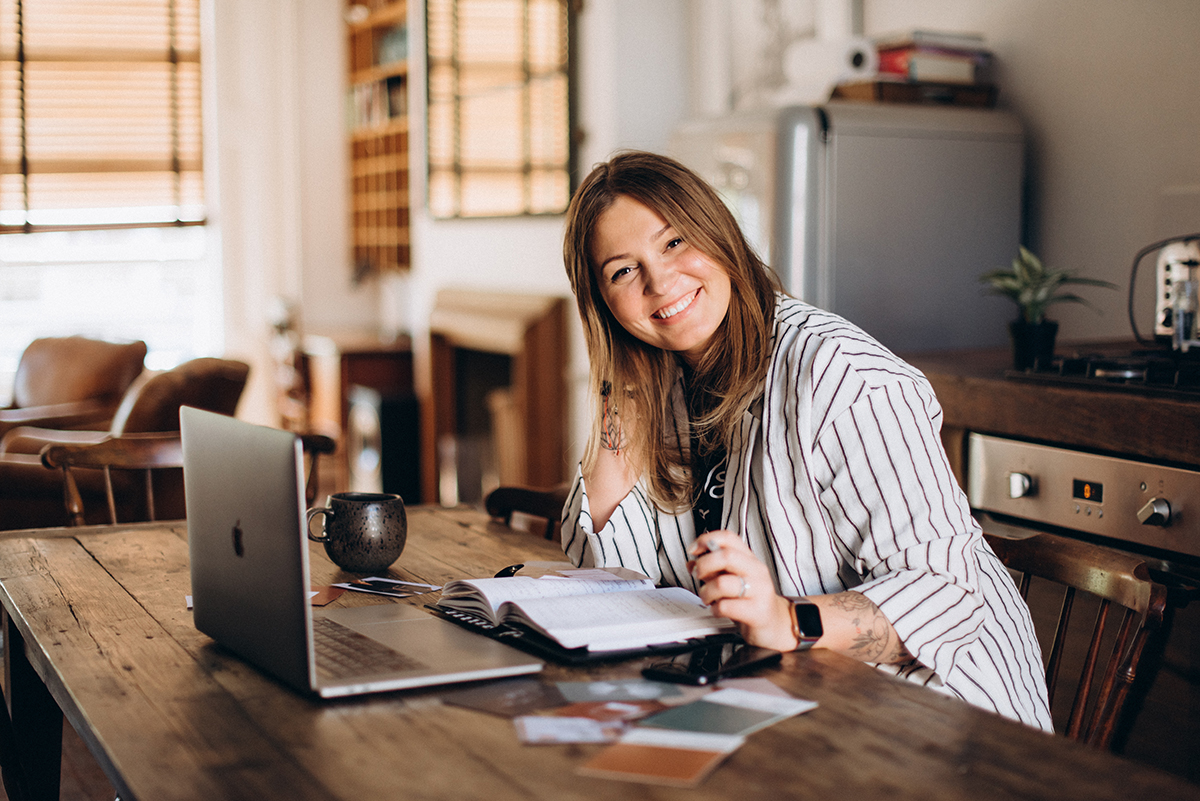 Female Entrepreneur Working at Desk Smiling